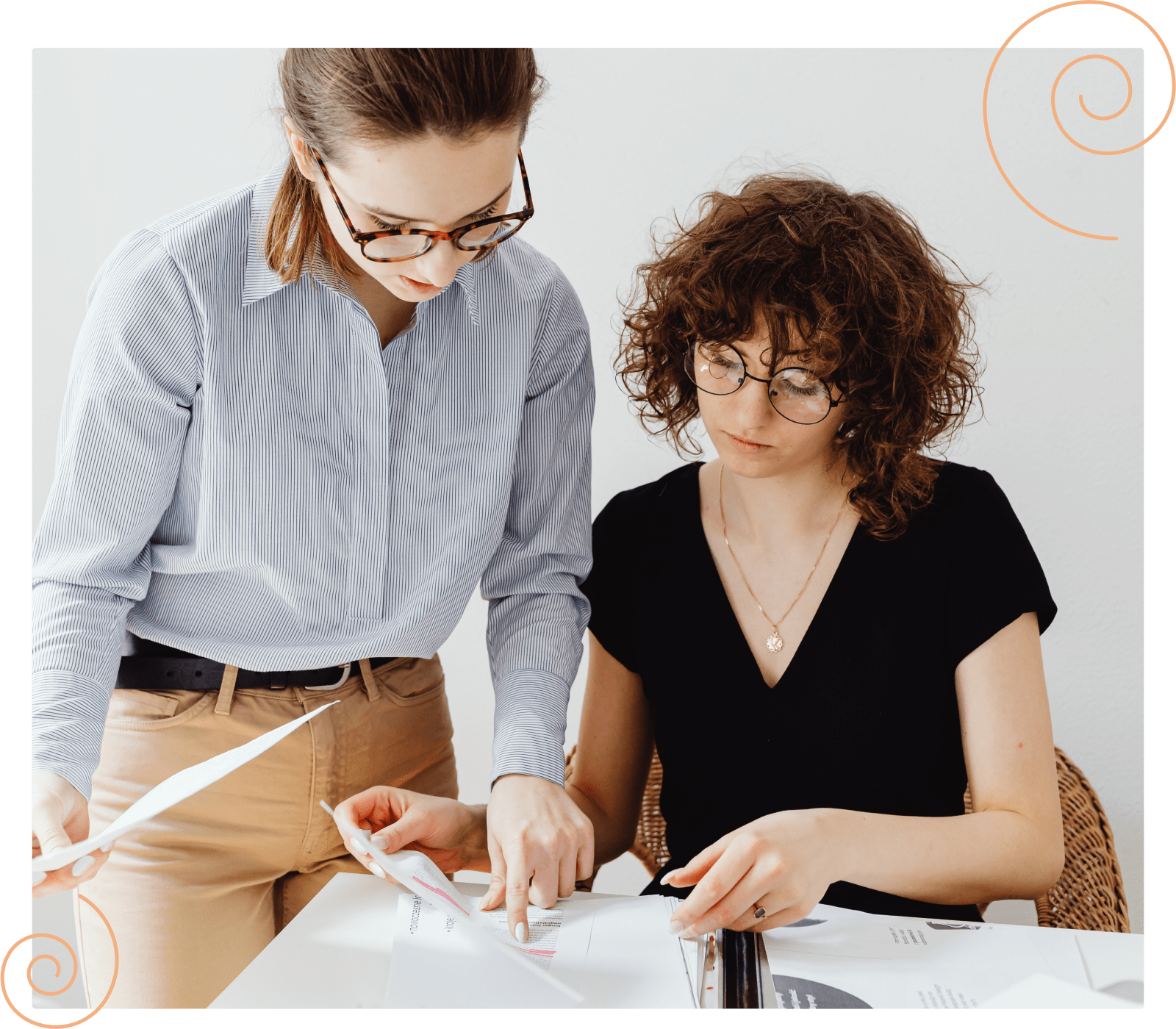 two business women looking down and working